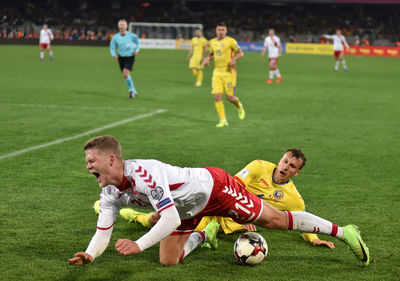 Men playing soccer on field