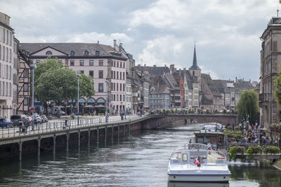 View of boats in river against cloudy sky