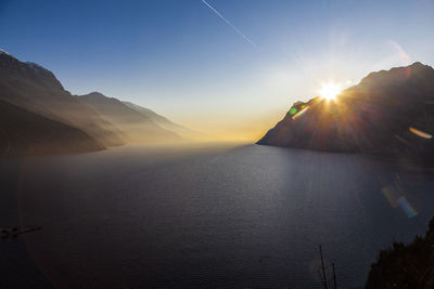 Scenic view of lake and mountains against sky at sunset