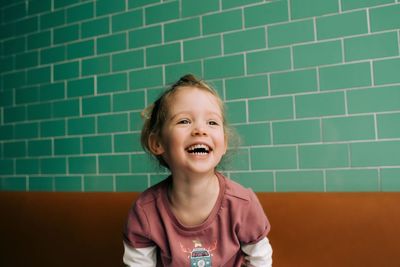 Portrait of young girl laughing and happy in restaurant