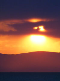 Scenic view of mountains against orange sky