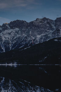 Scenic view of lake by mountains against sky