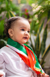 Cute toddler holding indian tricolor flag in traditional cloth with innocent facial expression