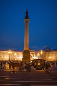 Statue in city at night