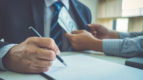 Cropped image of business colleagues working on table