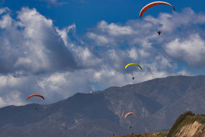 Low angle view of person paragliding against sky