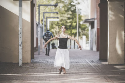 Full length of woman dancing on footpath