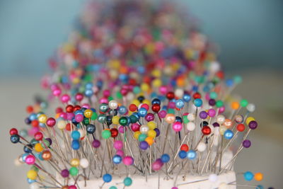 Close-up wallpaper of a group of pins stuck in foam on a green background. 