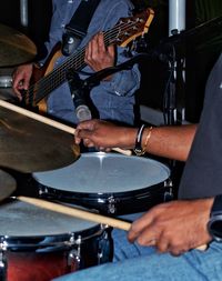 Midsection of man playing guitar at music concert