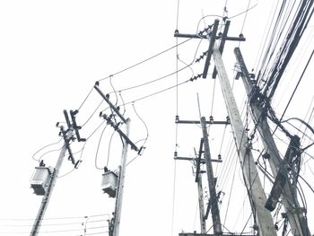 Low angle view of electricity pylon against clear sky