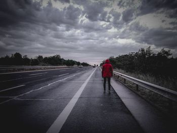 Rear view of man on road against sky