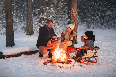 People sitting on snow covered land