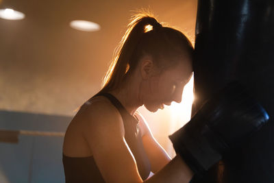 Side view of young woman exercising at home