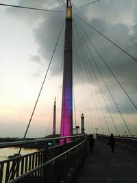 View of suspension bridge against cloudy sky