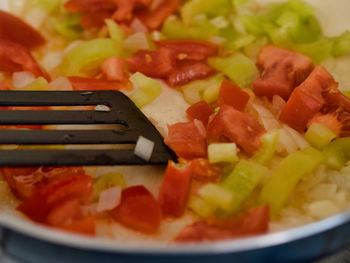 Close-up of chopped frying vegetables in plate, pan