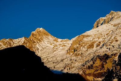 Scenic view of snowcapped mountains against clear blue sky