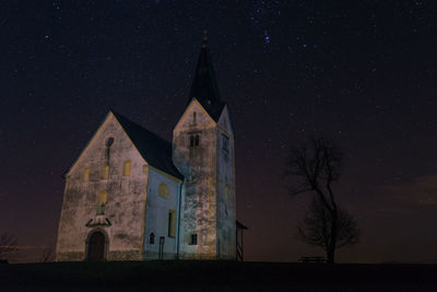 Low angle view of church against star field at night