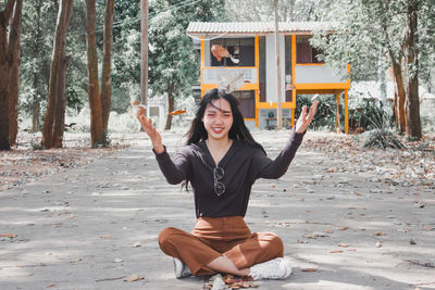 Portrait of smiling young woman sitting on land