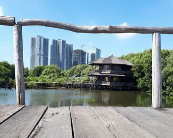 Buildings by lake against sky in city