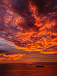 Scenic view of sea against dramatic sky during sunset