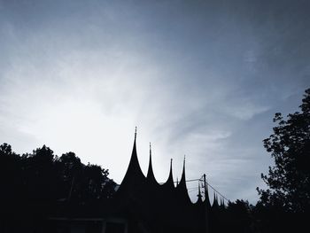 Low angle view of silhouette building against sky