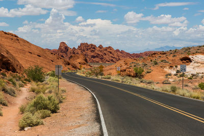 Road amidst desert against sky