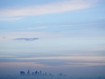 Aerial view of buildings against cloudy sky