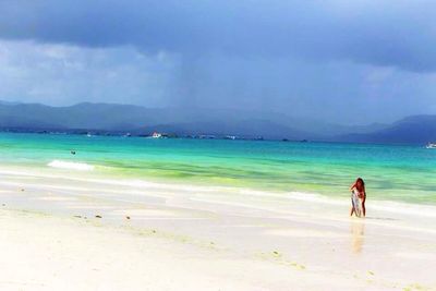 Scenic view of beach against cloudy sky