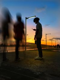 Low angle view of silhouette man walking on bridge