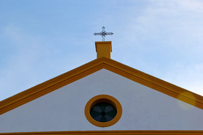 Low angle view of weather vane against sky