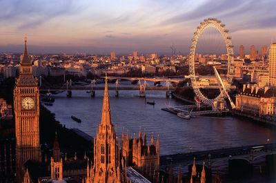 High angle view of thames river amidst modern buildings against cloudy sky