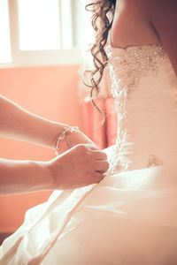 Midsection of woman with umbrella on bed