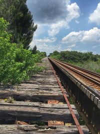 Railroad track against cloudy sky