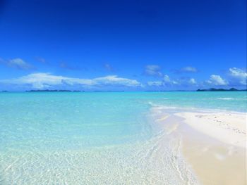 Scenic view of beach against blue sky