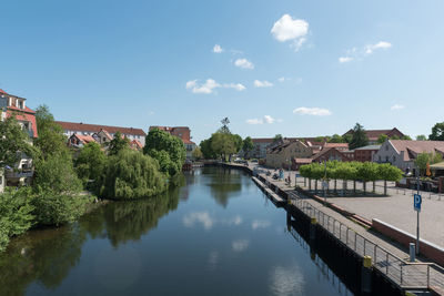 Bridge over river amidst buildings against sky