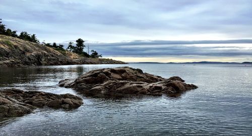 Rock formation in sea against sky