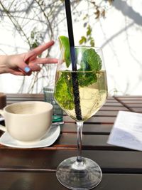 Midsection of woman pouring wine in glass on table