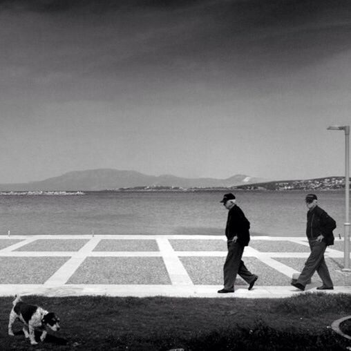 men, lifestyles, leisure activity, rear view, full length, road, copy space, transportation, road marking, person, standing, railing, street, clear sky, mountain, walking, day