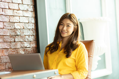 Portrait of smiling businesswoman using laptop in cafe