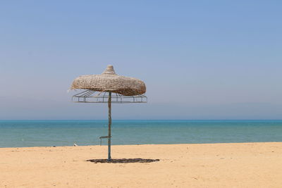 Lifeguard hut on beach against clear blue sky