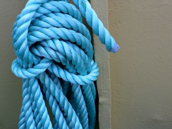 Coil of light blue rope against grey background