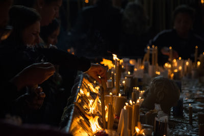 People lighting candles in church