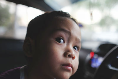 Close-up portrait of cute boy looking away