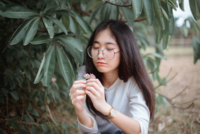 Portrait of beautiful young woman holding plant