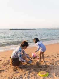 Rear view of woman sitting at beach