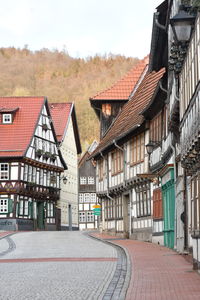 Houses by street against sky in city