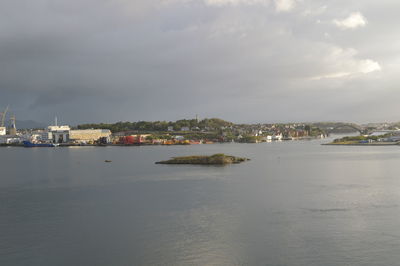 Scenic view of sea by buildings against sky