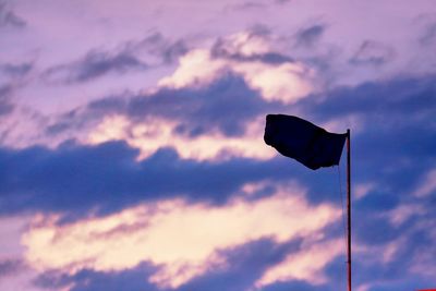 Low angle view of flag against sky at sunset