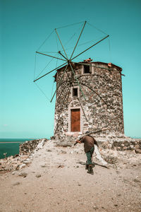 Man with umbrella on land against sky