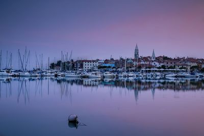 Sailboats moored at harbor